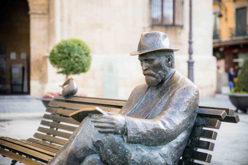 Escultura de Antoni Gaudí (obra de José Luis Fernández) delante de Casa Botines (León).